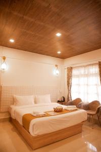 a bedroom with a large bed with a wooden ceiling at MOCAHM in Shillong