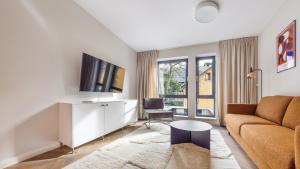 uma sala de estar com um sofá e uma televisão em City Center Apartments Bank Polski em Gdynia