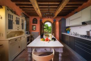 a kitchen with a table with fruits on it at PODERE SANTA CROCE 10, Emma Villas in Radicondoli