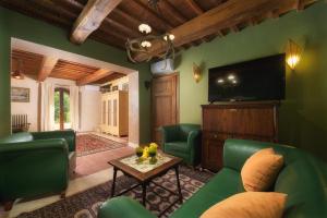 a living room with green furniture and a flat screen tv at PODERE SANTA CROCE 10, Emma Villas in Radicondoli