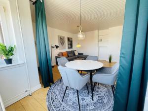 - un salon avec une table, des chaises et un canapé dans l'établissement aday - Modern charming apartment in Noerresundby, à Nørresundby