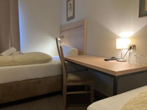 a hotel room with a desk and a bed and a table at Altes Sudhaus in Aschaffenburg