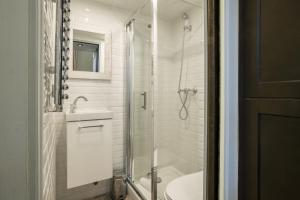Pick A Flat's Apartment in Saint-Germain des Près - Rue Paul Louis Courier في باريس: حمام مع دش ومغسلة ومرحاض