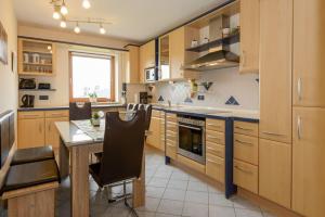a kitchen with wooden cabinets and a table with chairs at Ferienwohnung-Panoramablick-4 in Bodenmais
