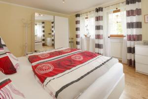 Schlafzimmer mit einem Bett mit einer roten und weißen Decke in der Unterkunft Ferienwohnung-Panoramablick -4 in Bodenmais