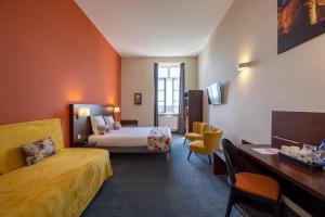 Rúm í herbergi á Hôtel Val-Vignes Colmar Haut-Koenigsbourg, The Originals Relais