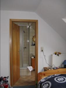 um quarto com um chuveiro e uma porta de vidro em Ferienhaus Ockholm em Ockholm