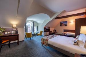 Rúm í herbergi á Hôtel Val-Vignes Colmar Haut-Koenigsbourg, The Originals Relais