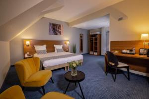 Rúm í herbergi á Hôtel Val-Vignes Colmar Haut-Koenigsbourg, The Originals Relais