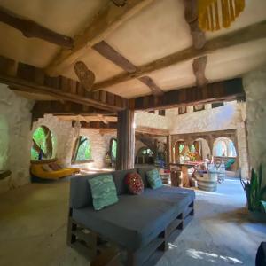 - un salon avec un canapé bleu dans une pièce aux murs en pierre dans l'établissement Portal Xibalba, à Playa del Carmen