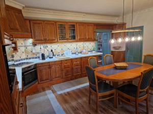 uma cozinha com armários de madeira e uma mesa com cadeiras em Jókai Apartment em Sopron