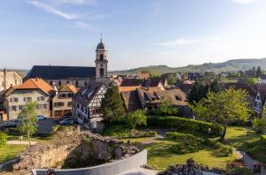 eine kleine Stadt mit einem Uhrturm in der Ferne in der Unterkunft Hôtel Val-Vignes Colmar Haut-Koenigsbourg, The Originals Relais in Saint-Hippolyte