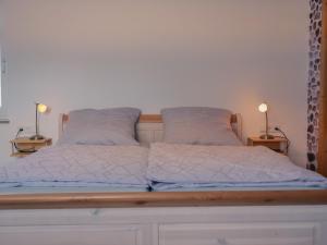 a bed with white sheets and pillows on it at PfalzZeit in Weisenheim am Berg