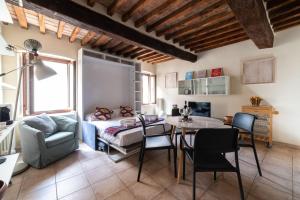 ein Wohnzimmer mit einem Bett, einem Tisch und Stühlen in der Unterkunft A due passi della casa natale del Maestro Toscanini in Parma