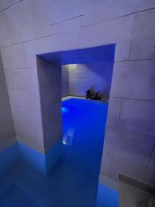 Cette chambre est dotée d'un sol bleu et d'un mur en briques. dans l'établissement Handy Specus, à Brindisi