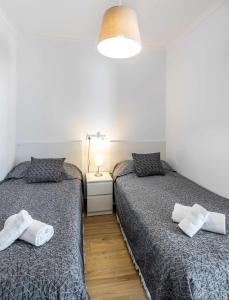 - une chambre avec 2 lits et une lampe sur du parquet dans l'établissement Inftour President 2 Apartamento, à Calp
