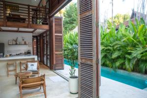 - une cuisine ouverte et un coin repas dans une maison avec piscine dans l'établissement Villa Merbau - Luxury Tropical Private Pool Villa, à Gili Air