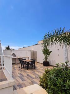 - une terrasse avec une table et des chaises dans un bâtiment dans l'établissement Pescoluse Apartments, à Marina di Pescoluse