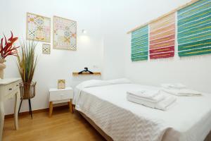 - une chambre avec un lit blanc et des serviettes dans l'établissement Z - Gil Vicente Guest Rooms, à Lagos