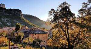 a village in the mountains with the sun shining on it at Private room with stunning view Gorges du Verdon in Castellane