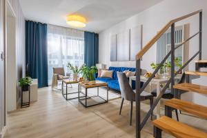 a living room with a blue couch and a table at Deluxe Apartments by The Railway Station Wroclaw in Wrocław