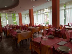 a dining room with tables with red and yellow tablecloths at Albergo Rita in Rimini