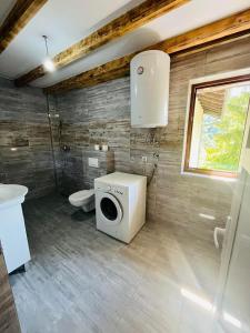 ein Badezimmer mit einer Waschmaschine und einem WC in der Unterkunft Family home near river Una / 3D in Bihać
