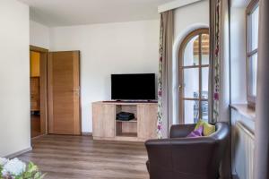 ein Wohnzimmer mit einem TV und einem Stuhl in der Unterkunft Rotkäppchen Schlosshof in Umes