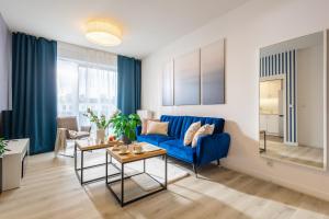 Deluxe Apartments by The Railway Station Wroclaw - MAMY WOLNE POKOJE ! في فروتسواف: غرفة معيشة مع أريكة زرقاء وطاولة