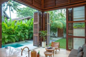 sala de estar con vistas a la piscina en Villa Merbau, en Gili Air