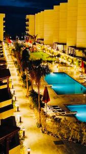 Porto Said Resort Rentals في بورسعيد: اطلاله على مسبح بالنخيل ومبنى