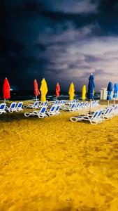Porto Said Resort Rentals في بورسعيد: مجموعة من كراسي الشاطئ والمظلات على الشاطئ