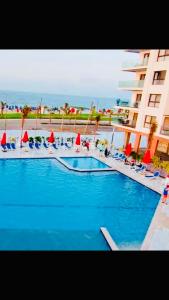 a large swimming pool with chairs and a building at Porto Said Resort Rentals in Port Said