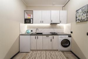 利維夫的住宿－Luxury apartment in downtown，厨房配有白色橱柜和洗衣机。