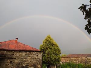 un arc-en-ciel derrière un bâtiment et un bâtiment en pierre dans l'établissement Bed & breakfast Gevorgyans', à Tatev