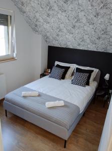 a bedroom with a large bed with two towels on it at Apartament Nowy Władek 2 in Władysławowo