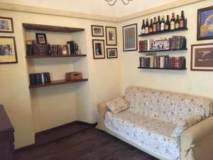 a living room with a couch and shelves with books at Entroterra Langa in Borgomale