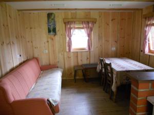 um quarto com um sofá e uma mesa num quarto em Koča na planini Jelje - Pokljuka em Goreljek