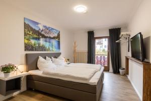 紹爾格魯布的住宿－Gasthof zur Post Saulgrub，一间卧室配有一张大床和电视