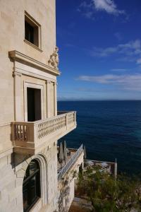 un edificio con balcone affacciato sull'oceano di Hotel Hospes Maricel y Spa a Cas Català