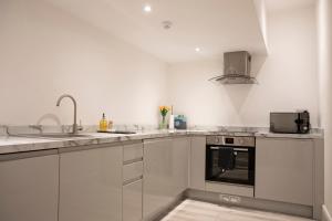 a white kitchen with a sink and a stove at #5 Grimston St Apartment near Hull New Theatre and Connexin Live in Hull