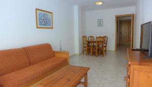 a living room with a couch and a table and chairs at Apartamentos Zahara Palmyra in Salou
