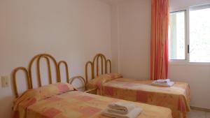 a room with two beds and a window at Apartamentos Zahara Palmyra in Salou