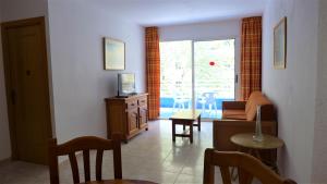 a living room with a couch and a table and a window at Apartamentos Zahara Palmyra in Salou