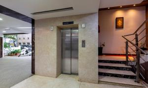 バンガロールにあるItsy Hotels Hiland Suitesの回転ドアと階段のあるロビー
