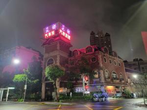 高雄的住宿－花鄉旅館連鎖-大昌店 ，一座建筑的顶部有一个钟楼