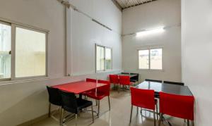 a dining room with red tables and chairs at Treebo Trend Hiland Suites in Bangalore