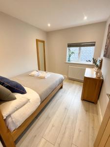 a bedroom with a bed and a wooden floor at Luxurious Apartment Just Off Mill Rd in Cambridge
