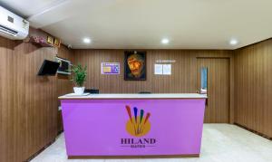 バンガロールにあるItsy Hotels Hiland Suitesのロビーのピンクカウンター(シンガポールサイン付)