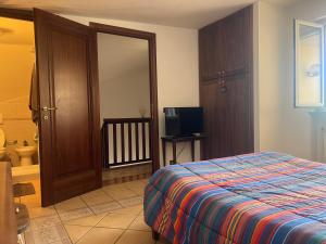 1 dormitorio con 1 cama y TV en Villa TANA Ryder Cup 2023 Marco Simone Golf Club at 6 kilometres, en Fonte Nuova